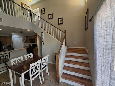 Stairway featuring a towering ceiling and baseboar