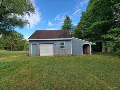 View of shed / structure with a garage and a lawn