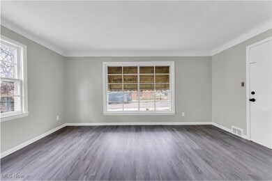 Spare room with a wealth of natural light, dark wood-style floors, baseboards, and visible vents