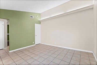 Empty room featuring light tile patterned floors and lofted ceiling