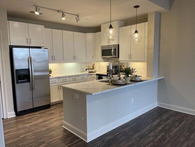 Kitchen featuring white cabinetry, hanging light f