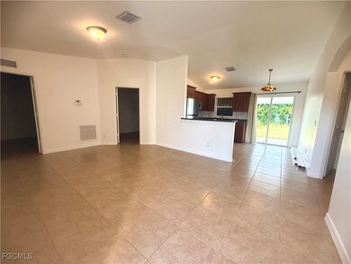 Unfurnished living room featuring lofted ceiling, arched walkways, and light tile patterned floors