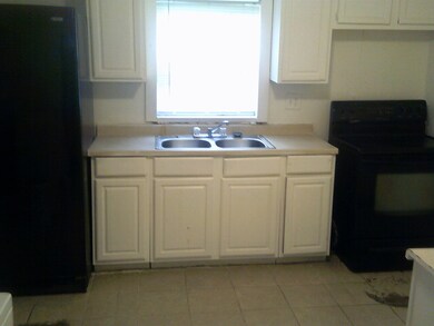 Kitchen with stove, sink, light tile patterned flo