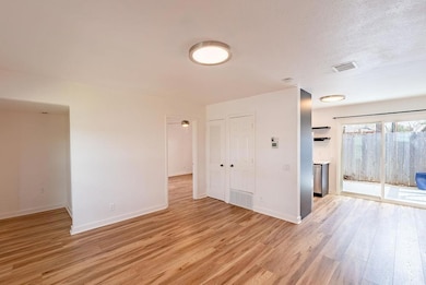 Unfurnished room featuring visible vents, light w