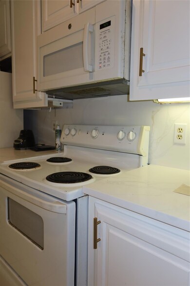 Kitchen featuring electric range, light counterto