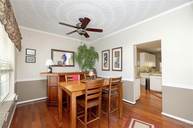 Dining area featuring ornamental molding, dark woo