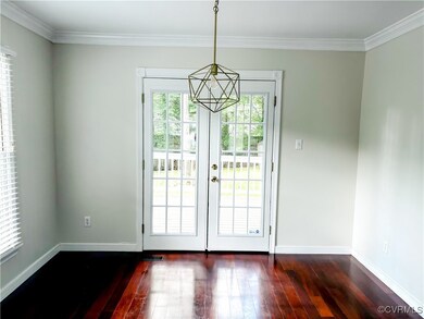 Doorway featuring dark wood finished floors, crown