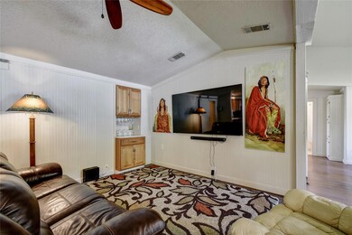 Living room with a ceiling fan, a textured ceilin