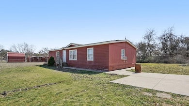 View of side of home with cooling unit and a lawn