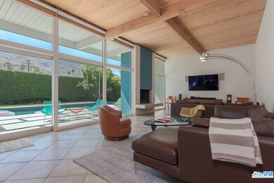Living room with fireplace overlooks pool