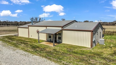 Back of house with a yard and a metal roof