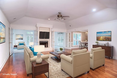 Expansive Great Room Highlighted by a Gas Log Fireplace, Hardwood Floors, Plantation Shutters, and a Dramatic 10 Ft Coffered Ceiling—Ideal for Both Entertaining and Everyday Living.