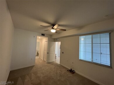 Spare room featuring a ceiling fan, carpet, and ba