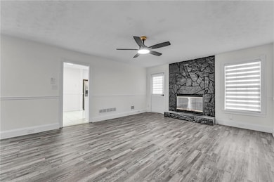Unfurnished living room featuring baseboards, a fi
