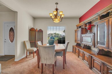 Dining room featuring light carpet and a chandelie