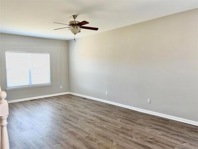 Spare room featuring dark wood-style floors, visible vents, a ceiling fan, and baseboards