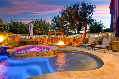This backyard can be enjoyed year round with this fire pit and the heated pool and spa.