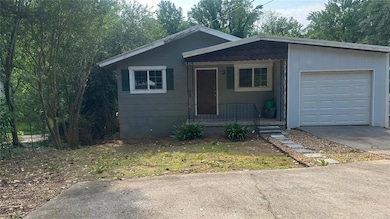 View of front of house with driveway, a garage, and covered porch