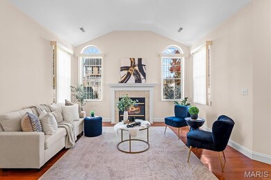Living room featuring dark wood finished floors, lofted ceiling, and a tile fireplace