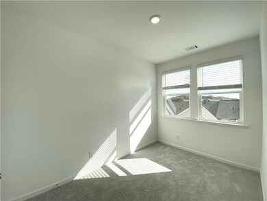 Carpeted spare room featuring baseboards