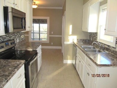 The kitchen is situated between the breakfast nook and the dining room. Tile floors, new countertops, and new appliances.