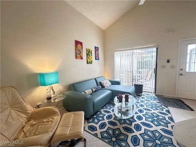 Tiled living room with high vaulted ceiling and a