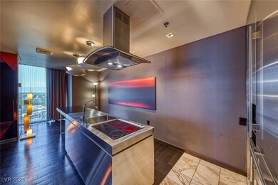 Kitchen featuring island exhaust hood, a center island with sink, black electric stovetop, floor to ceiling windows, and baseboards