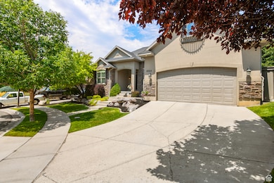 View of front of house featuring stone siding, stucco siding, driveway, and an attached garage