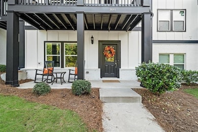Doorway to property with board and batten siding, brick siding, and covered porch