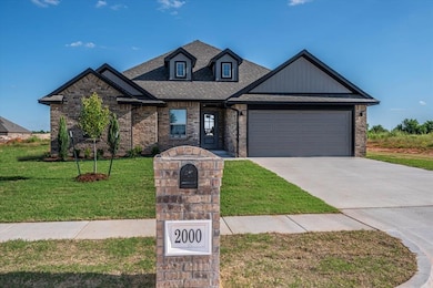 View of front of house featuring concrete driveway, a garage, a front yard, brick siding, and roof with shingles
