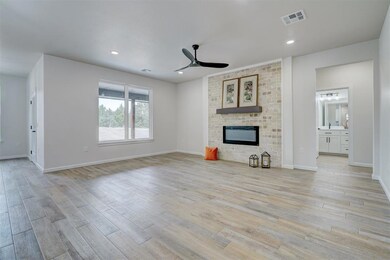 Living room with light hardwood / wood-style tile plank flooring, ceiling fan, and a fireplace