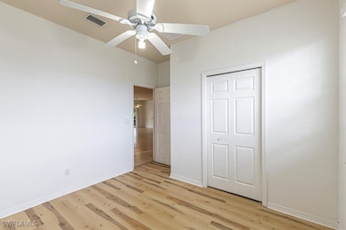 Unfurnished bedroom with light wood finished floors, ceiling fan, and a closet