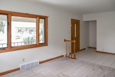 The living room features a large picture window.