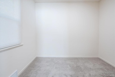 Carpeted empty room featuring baseboards