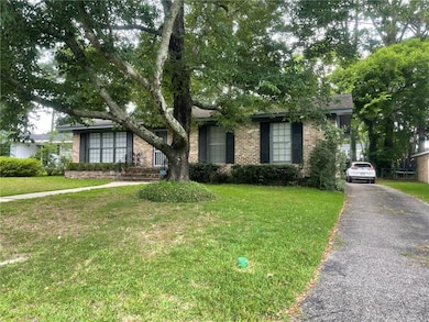 View of front facade with brick siding and a front lawn