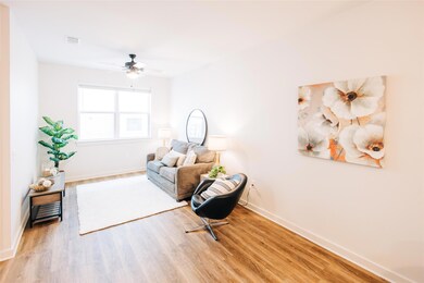 Sitting room with light wood-style floors and ceiling fan