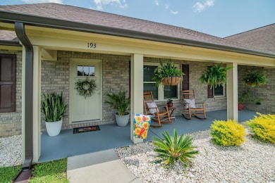 Doorway to property featuring covered porch, brick