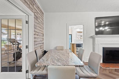 Dining space with a glass covered fireplace and wood finished floors