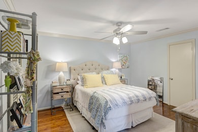 Well-sized primary bedroom featuring elegant crown