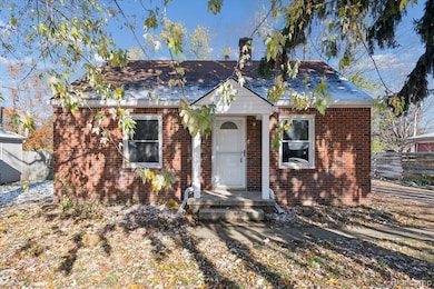Bungalow with brick siding, a chimney, and a shingled roof