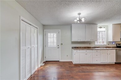 Kitchen with dark wood-style flooring, stainless s