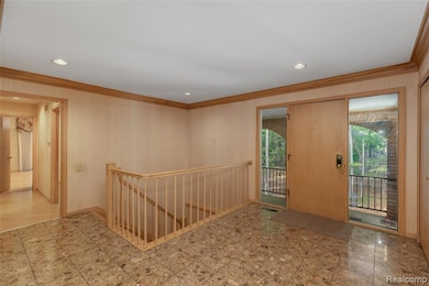 Entrance foyer featuring crown molding, recessed lighting, and wallpapered walls