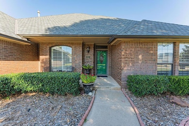 View of exterior entry with a shingled roof and brick siding