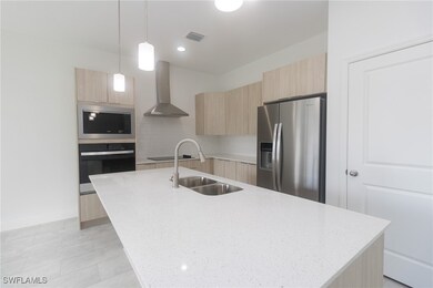 Kitchen featuring light brown cabinets, a sink, wa