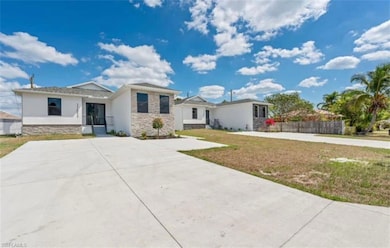 View of front of property with stone siding, stucco siding, a front lawn, and driveway