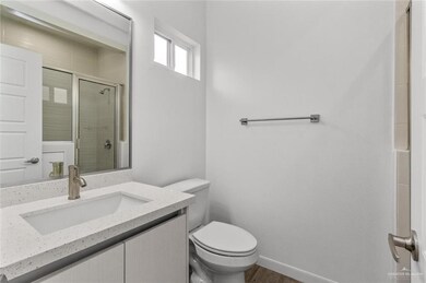 Full bathroom featuring a stall shower, wood finished floors, vanity, baseboards, and toilet