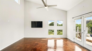 Unfurnished room with high vaulted ceiling, concr