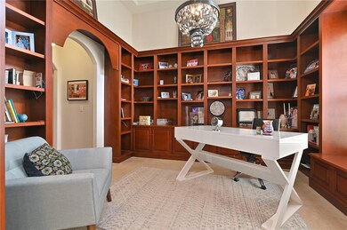 The office has custom bookshelves, high ceiling an