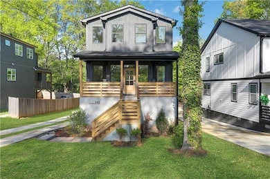 View of front of property with covered porch, stairway, a front yard, and board and batten siding