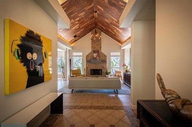 Tiled living room featuring a stone fireplace and